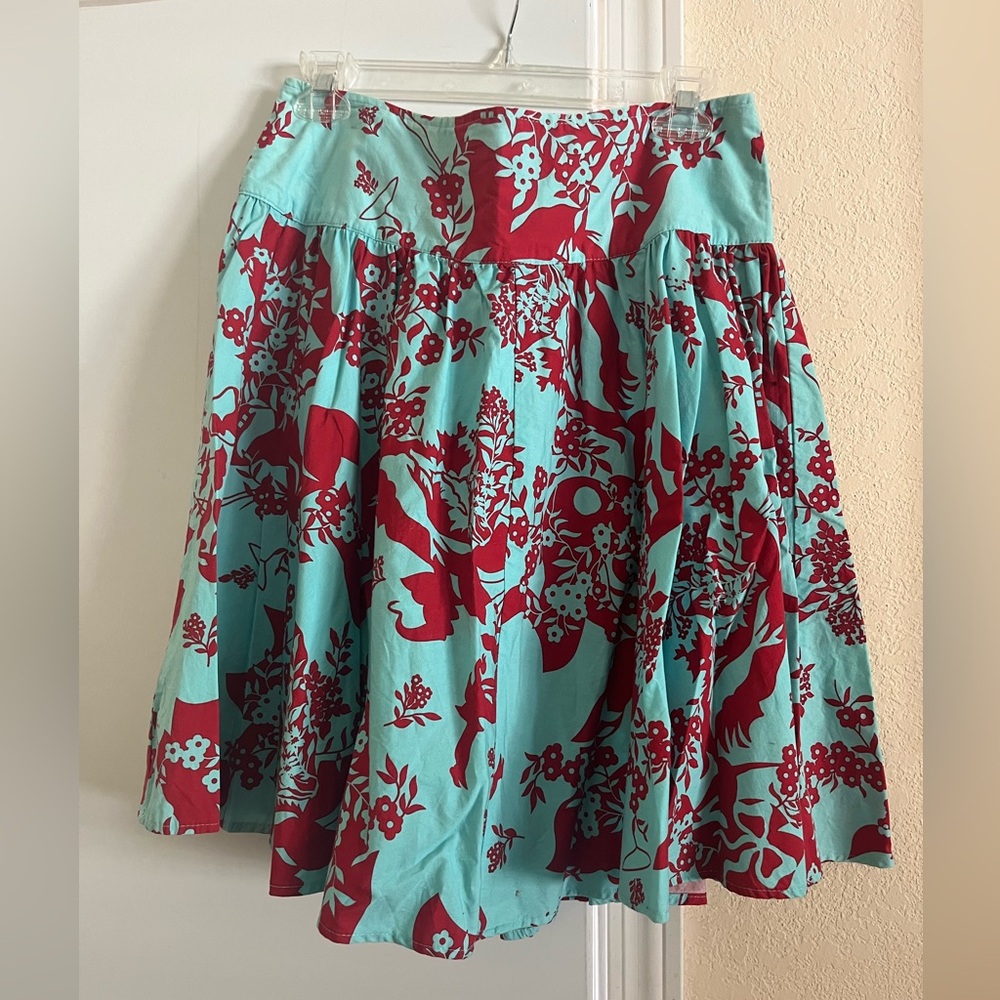 Lovely mid length teal colored pleated skirt with red hibiscus flowers pattern.
